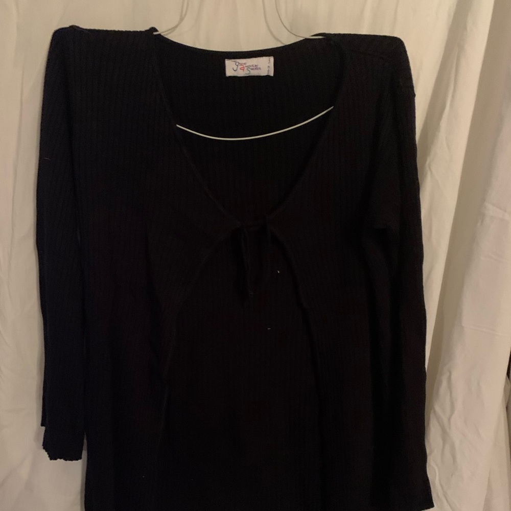 Long black women’s sweater.  Strings are in a knot.